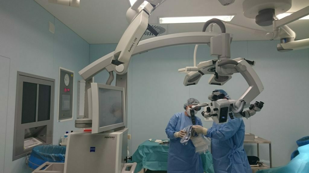 Divi ķirurgi operāciju zālē, izmantojot PENTERO 900 mikroskopu un medicīnisko aprīkojumu.