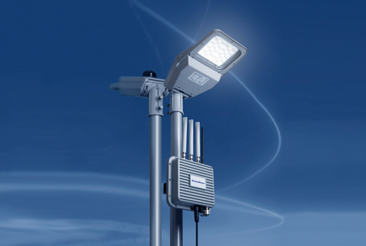 Gaismas stabs ar LED lampu un antenu, uz zilas debess fona. Rīgas 1. slimnīcas apkārtnē.