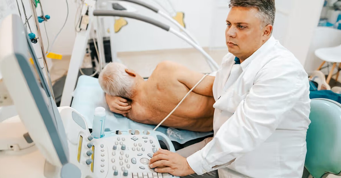 Ārsts veic ultraskaņas izmeklējumu pacientam Rīgas 1. slimnīcā. Pacients guļ uz sāniem.
