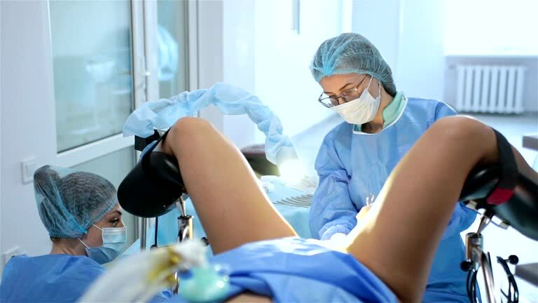 Divas medicīnas darbinieces veic procedūru, pacients atrodas ginekoloģiskajā krēslā. Rīgas 1. slimnīca.