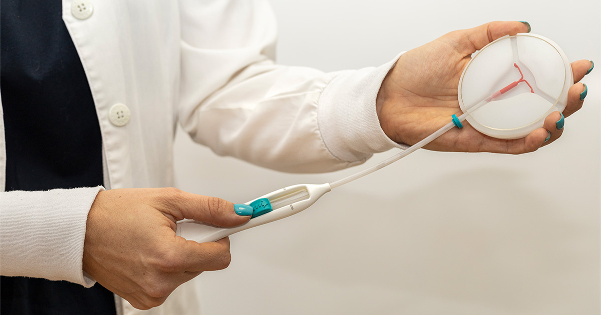 Rokā tur medicīnisks instruments ar balto un rozā daļu, kas var būt saistīts ar Rīgas 1. slimnīcu.