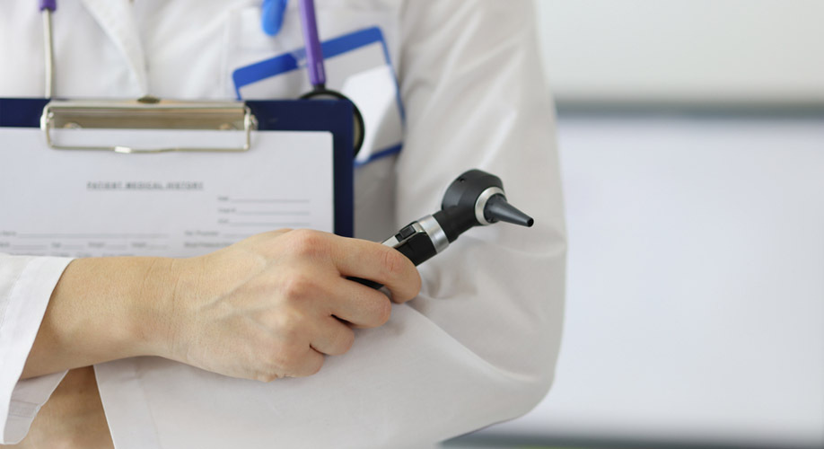 Otolaringologs sagatavo otoskopu – LOR ārsts veic ausu izmeklēšanu un diagnostiku