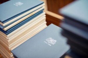 Zilā vāka grāmatas ar uzrakstu "Rīgas Dome" sakārtotas kaudzē.