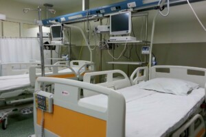 Gultas slimnīcā ar medicīnas aprīkojumu, Rīgas 1. slimnīca. Redzami monitori un gultas vadības paneļi.