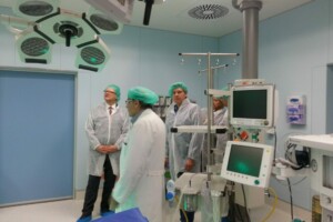 Apskate operāciju telpā Rīgas 1. slimnīcā, mediķi ar aizsargapģērbu un medicīnas iekārtām.