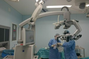 Divi ķirurgi operāciju zālē, izmantojot PENTERO 900 mikroskopu un medicīnisko aprīkojumu.