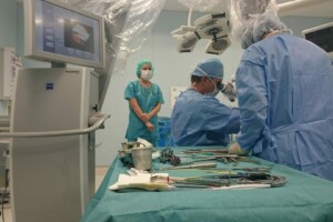 Operāciju telpa ar medicīnas personālu, instrumentiem un monitoru. Rīgas 1. slimnīcas vide.
