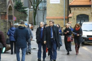 RD_komis_slimn_20160129 Cilvēki staigā pie Rīgas 1. slimnīcas, redzama zīme "Poliklīnika" uz ēkas.