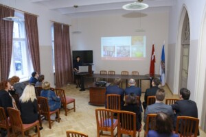 RD_komis_slimn_20160129 Konference Rīgas 1. slimnīcā, prezentācija par diagnostiku un rehabilitāciju, skatītāji pie galda.