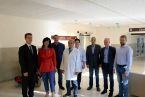 Rīgas 1. slimnīcas operāciju blokā grupas foto ar mediķiem un viesiem. Redzami septiņi cilvēki.