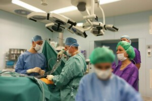 edf Ķirurģiskā telpa ar mediķiem, kas veic operāciju, valkājot maskas un ķirurģiskās drēbes. Rīgas 1. slimnīca.