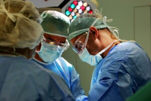 Divi ķirurgi operācijas laikā, valkājot maskas un aizsargbrilles, Rīgas 1. slimnīcā.