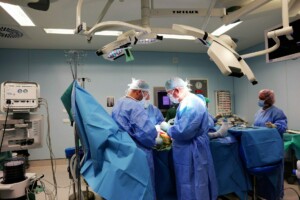 Ķirurģiska operācija Rīgas 1. slimnīcā, ārsti strādā pie pacienta, izmantojot medicīnisko aprīkojumu.