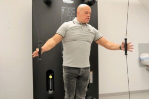 Vīrietis izmanto trenažieri "Technogym" Rīgas 1. slimnīcas rehabilitācijas centrā.
