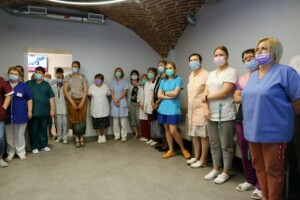 Rīgas 1. slimnīcas darbinieki grupā, visi valkā sejas maskas un medicīniskās drēbes.