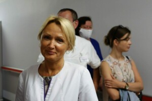 Sieviete baltā medicīnas tērpā, fona cilvēki, Rīgas 1. slimnīca.
