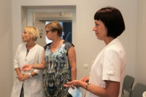 Trīs sievietes, divas medicīnas darbinieces un viena pacients, sarunājas Rīgas 1. slimnīcā.