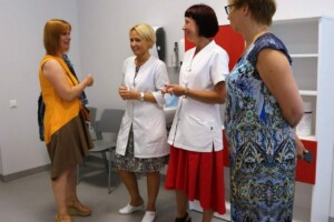 Četras sievietes sarunājas Rīgas 1. slimnīcas telpās, divas no tām ģērbtas medicīniskās drēbēs.