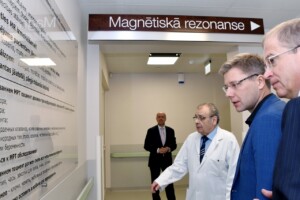 rd_1slimnica_20160418 Trīs vīrieši, viens balta apģērbā, skatās uz informācijas sienu par magnētisko rezonansi. Rīgas 1. slimnīca.