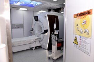 rd_1slimnica_20160418 MRI iekārta ar brīdinājuma zīmi par 3.0T magnētu Rīgas 1. slimnīcā. Gulta un medicīnas aprīkojums.