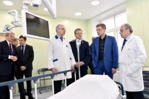 rd_1slimnica_20160418 Četri vīrieši un ārsts Rīgas 1. slimnīcā, stāv pie gultas un skatās uz ekrānu. Gaismas un mūsdienīga vide.